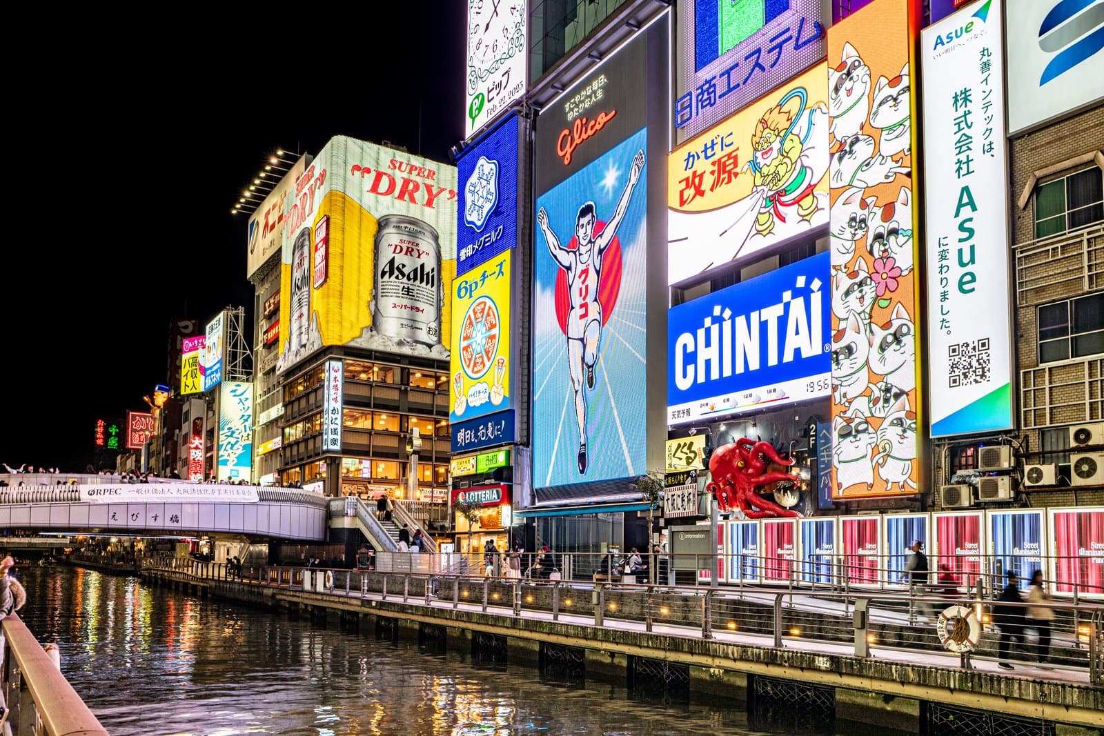 Dotonbori canal at night with the Glico running man sign, giant illuminated billboards and the Ebisubashi bridge