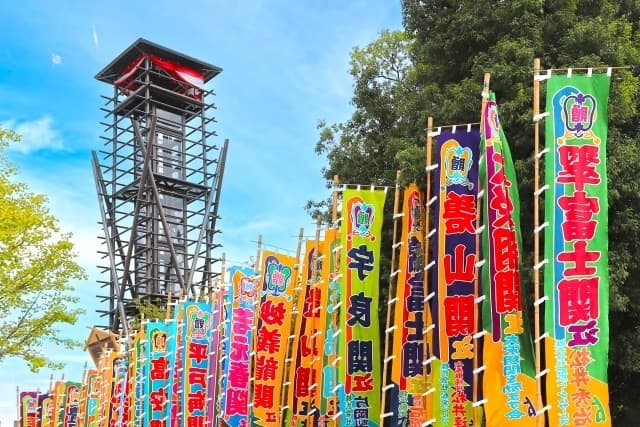 Rows of tall, brightly coloured sumo nobori banners bearing wrestlers' names outside Ryogoku Kokugikan during a tournament