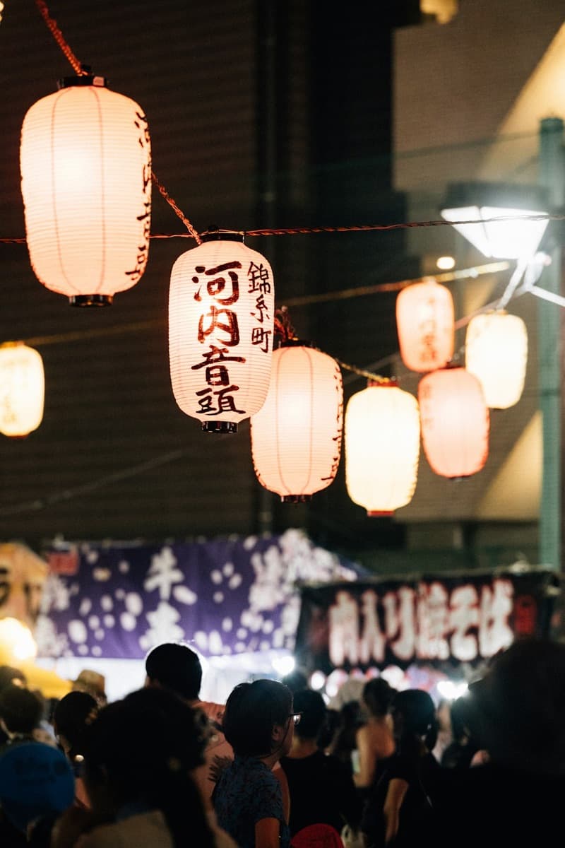 Leuchtende japanische Papierlaternen bei einem Sommerfest in der Nacht
