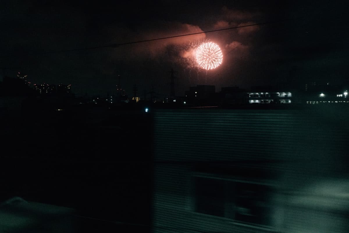 Feuerwerk über der nächtlichen Skyline einer Stadt während eines japanischen Sommerfests
