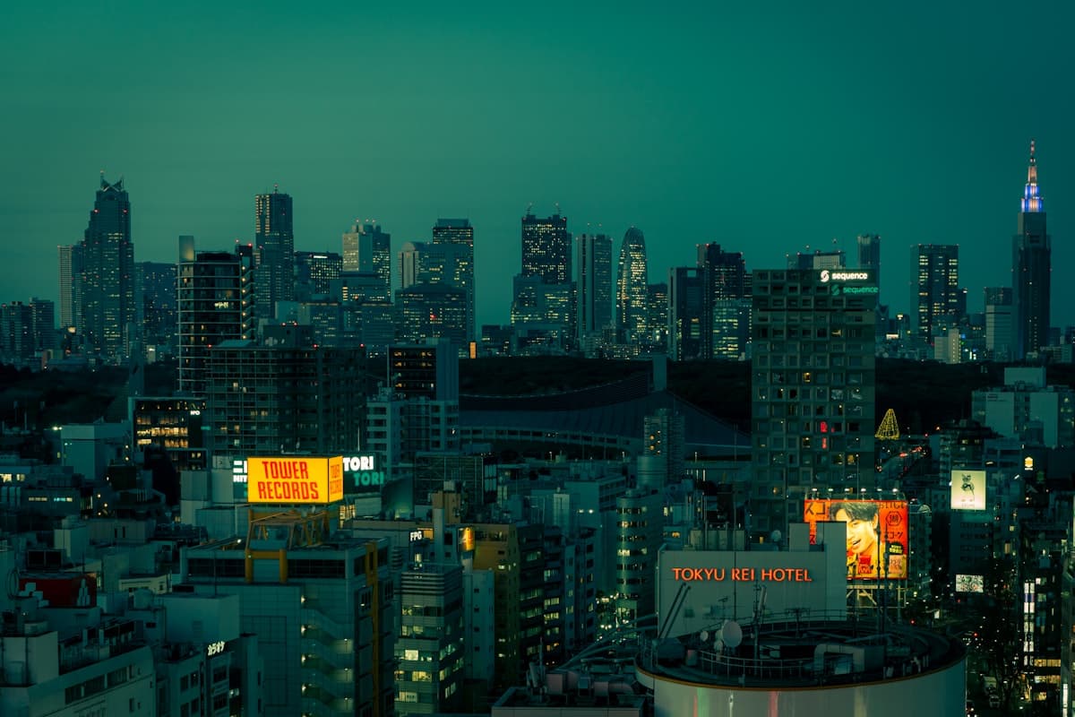 Die Skyline von Tokio bei Nacht von einem Hochhaus in Shinjuku aus, die Lichter der Stadt reichen bis zum Horizont