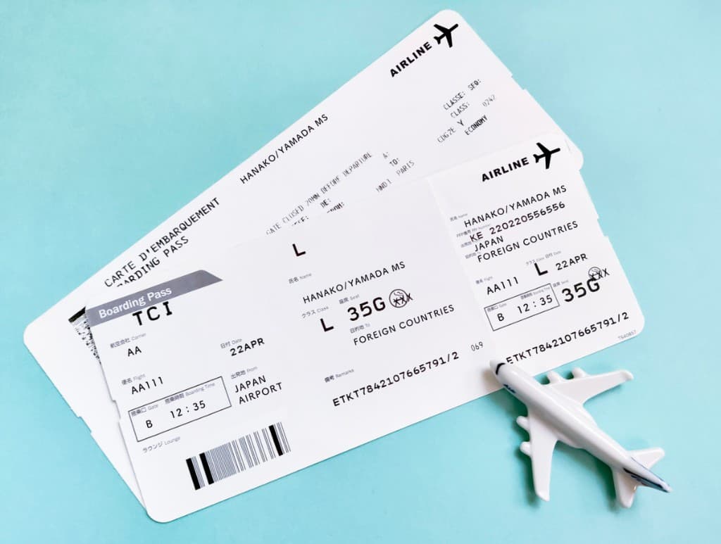 Airline boarding passes and a model airplane on a light blue background