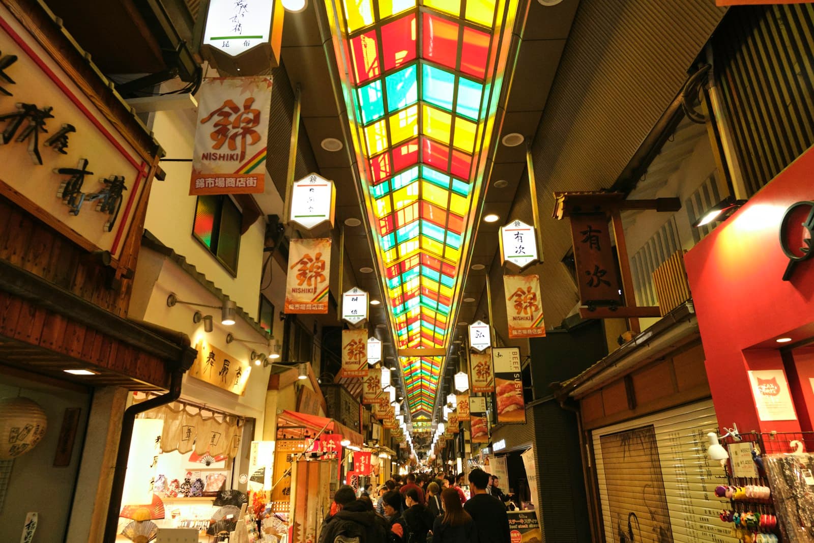 Nishiki Market arcade in Kyoto with food stalls and shoppers