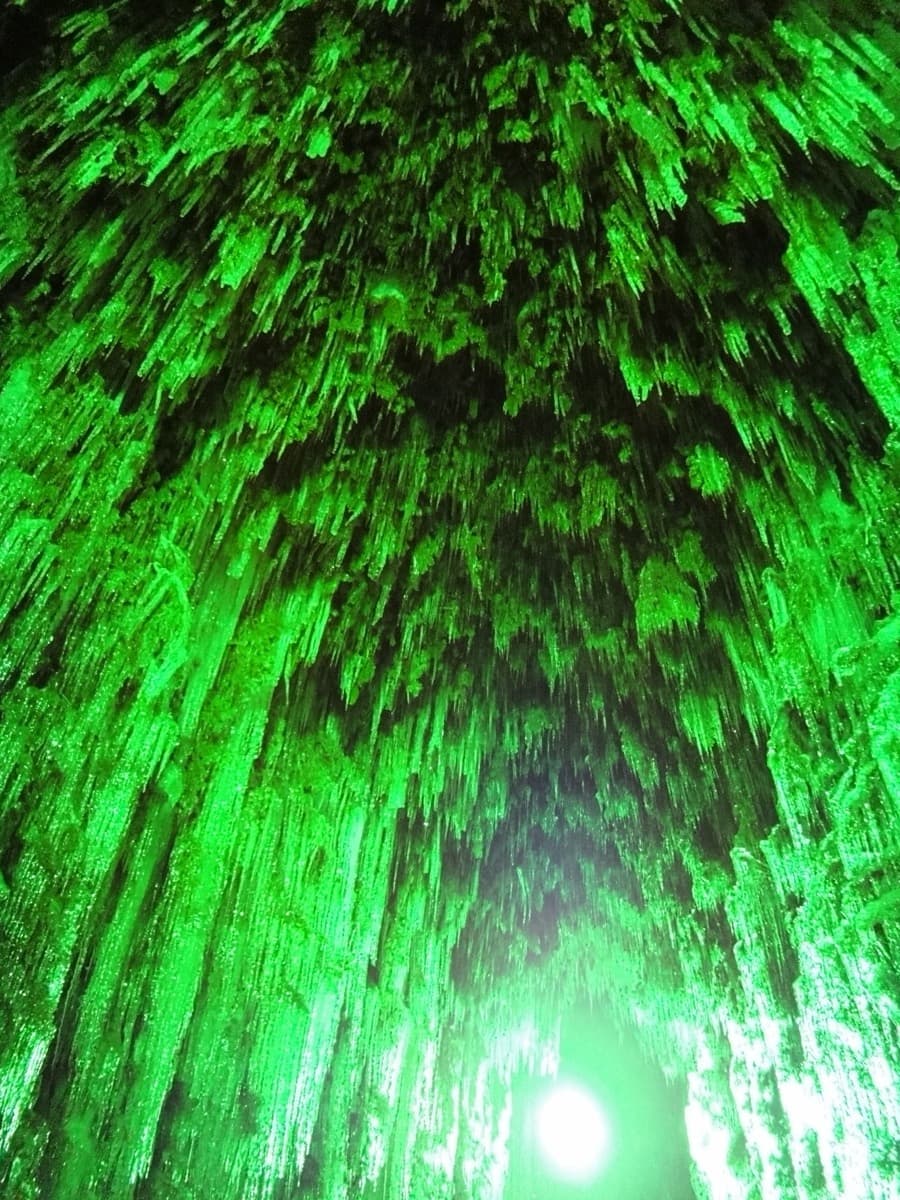 Layered icicles inside an ice structure at the Lake Shikotsu Ice Festival, lit deep green from within