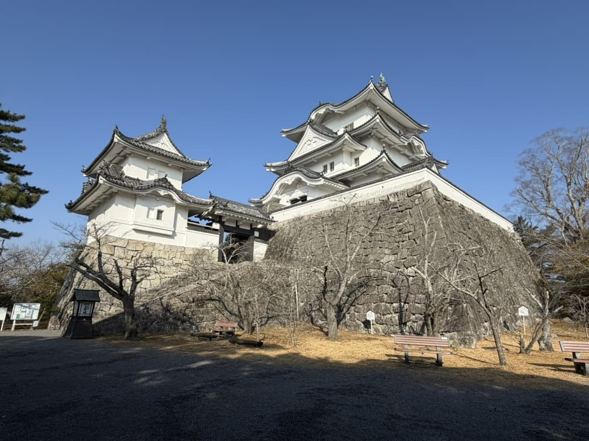 The white keep of Iga Ueno Castle above its high stone walls under a clear winter sky