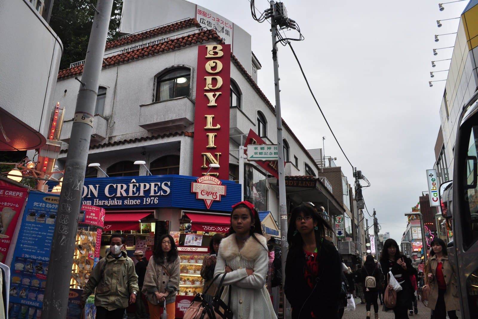 Shoppers walking past crepe stands and fashion stores on Takeshita Street in Harajuku