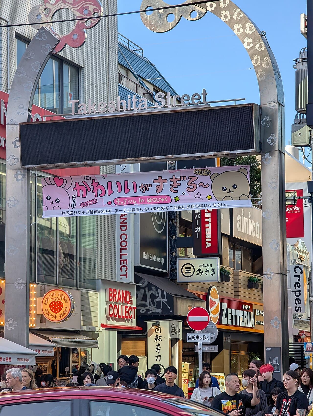 Crowds under the Takeshita Street entrance arch in Harajuku, Tokyo