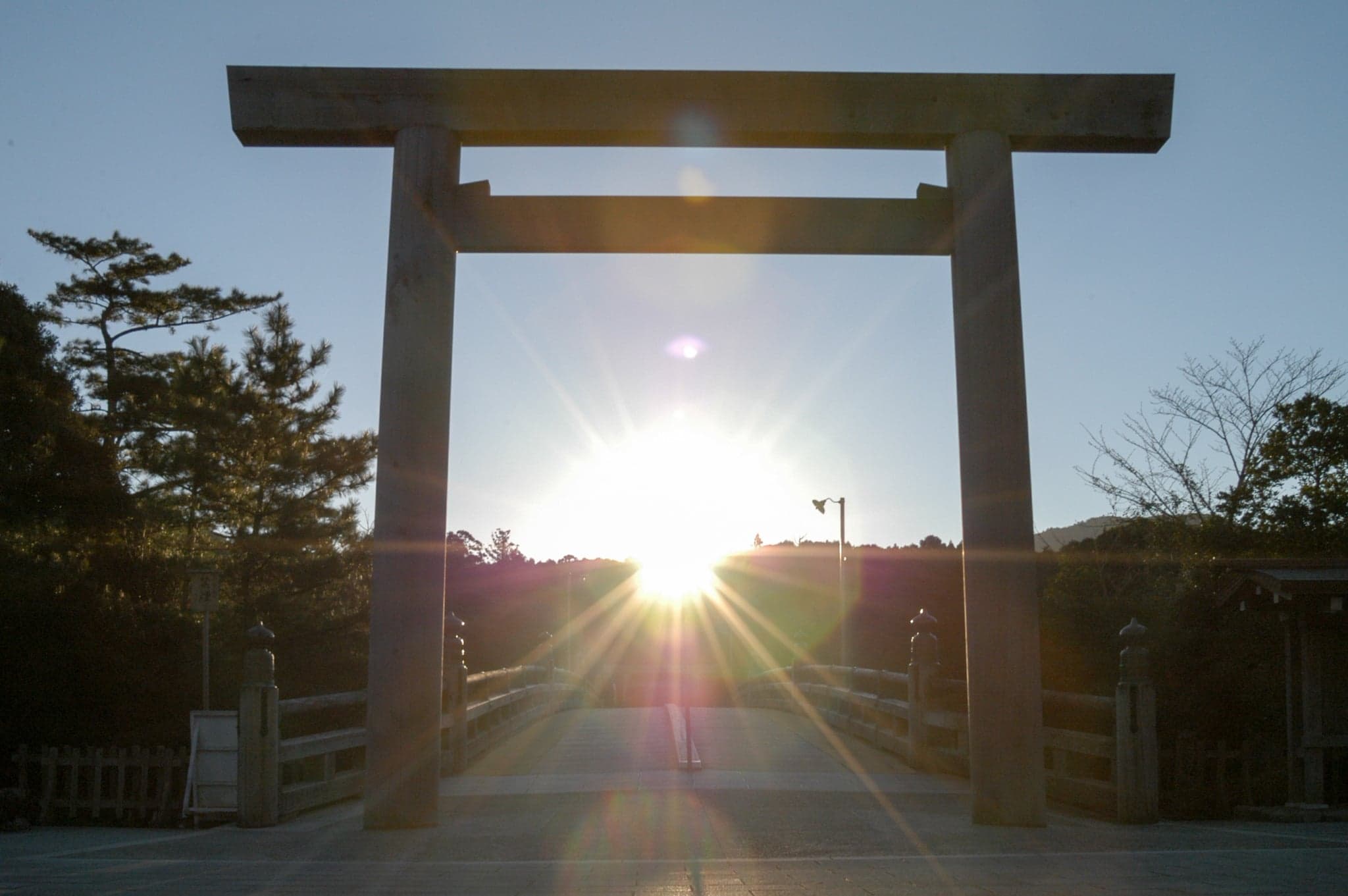 Sunrise seen through the wooden torii at the Uji Bridge entrance to Ise Jingu