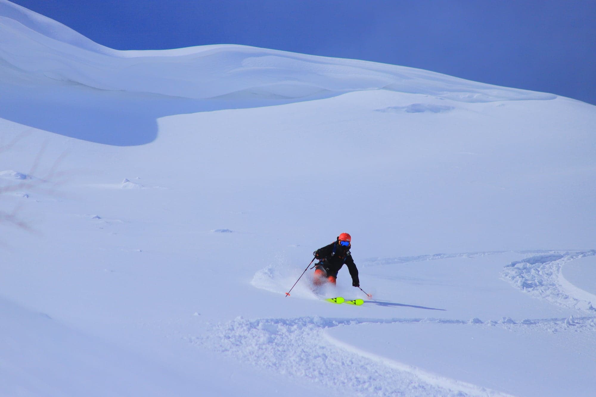 A lone skier making a turn through deep untracked powder in central Hokkaido