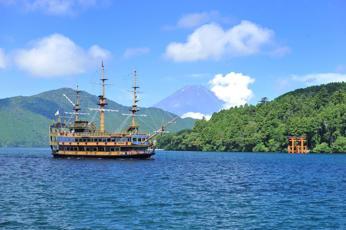 A pirate-style sightseeing ship on Lake Ashi with Mount Fuji rising behind green hills