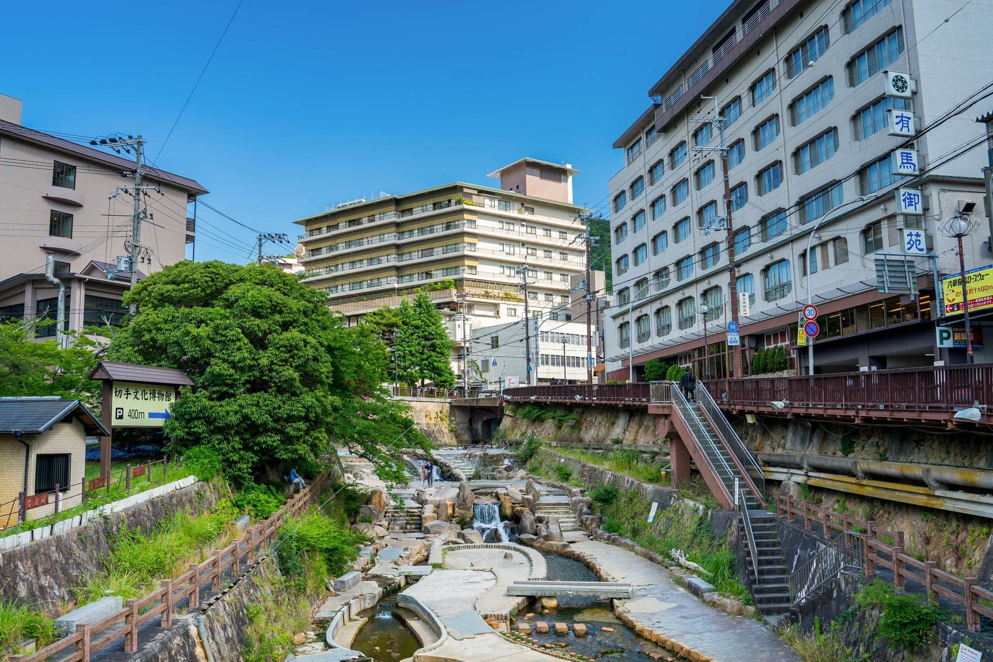 Arima Onsen's small river lined with stone steps and inn buildings climbing the hillside