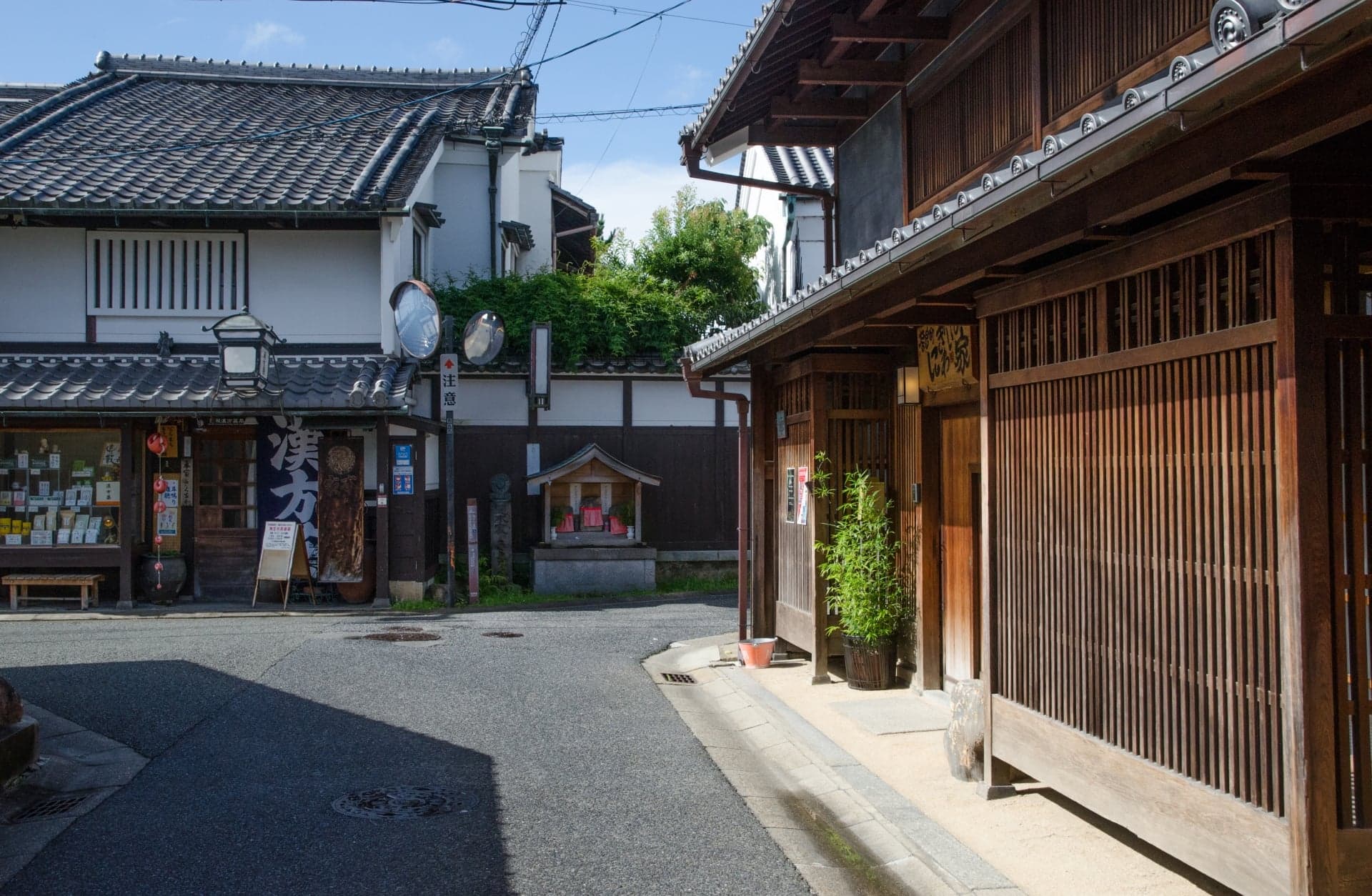 A quiet lane of old wooden townhouses with latticed fronts and tiled roofs in Nara