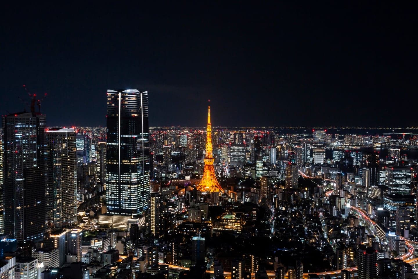 Tokyo Tower lit in orange at night above the city lights