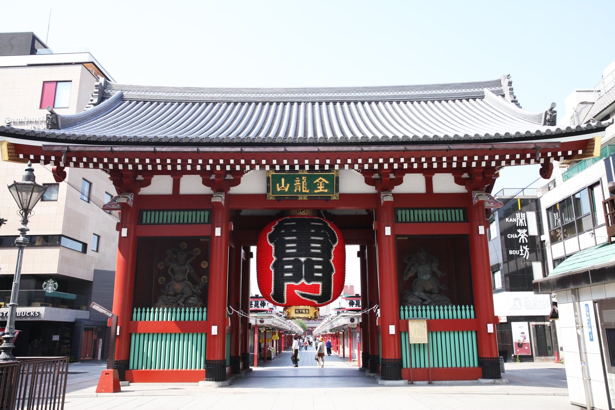The red Kaminarimon gate of Senso-ji with its giant paper lantern, under a clear sky