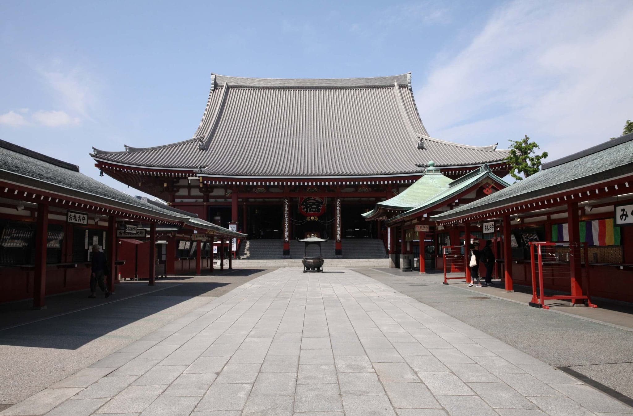 The main hall of Senso-ji across a wide, nearly empty paved courtyard in the morning