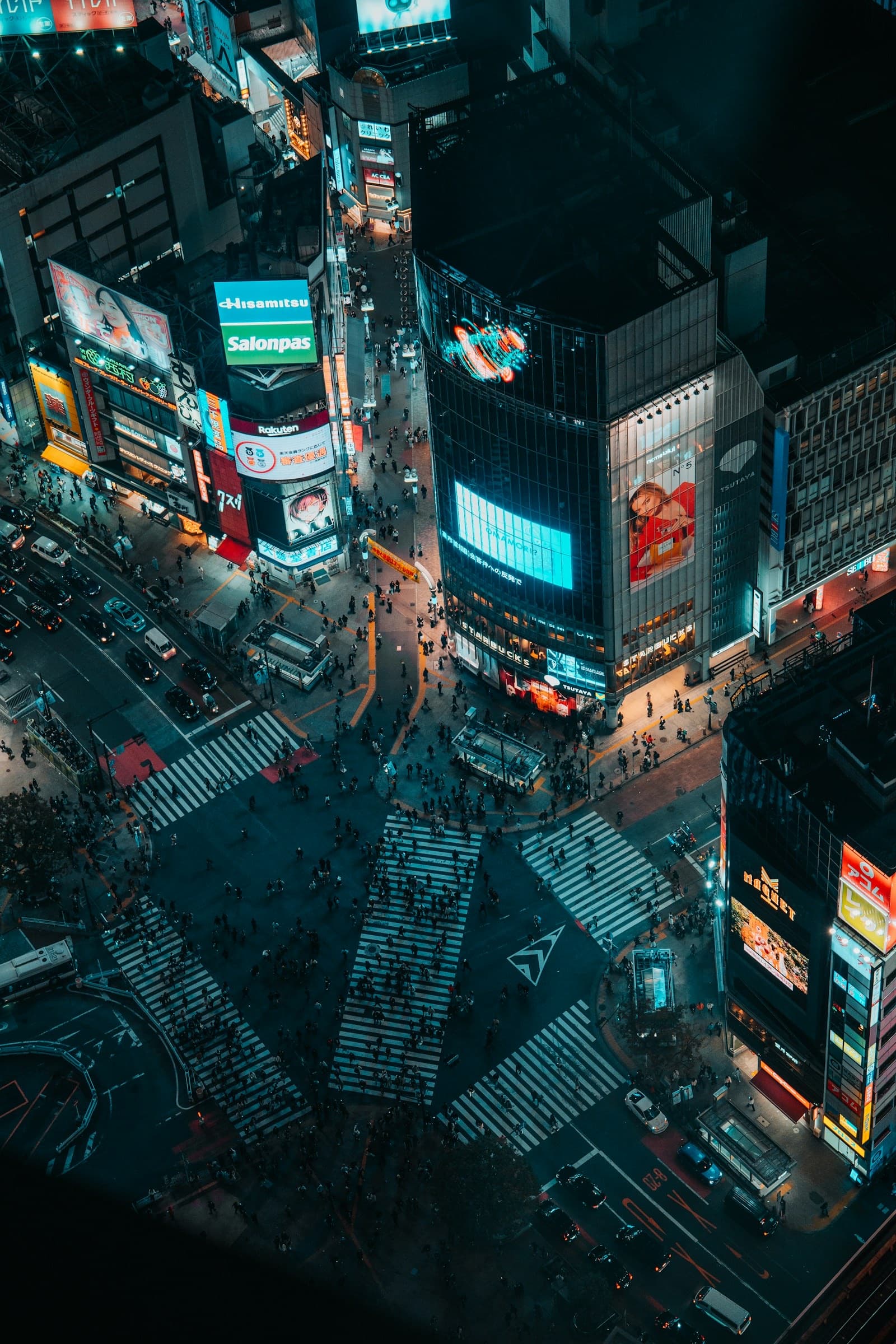Shibuya Crossing at night with neon lights and crowds