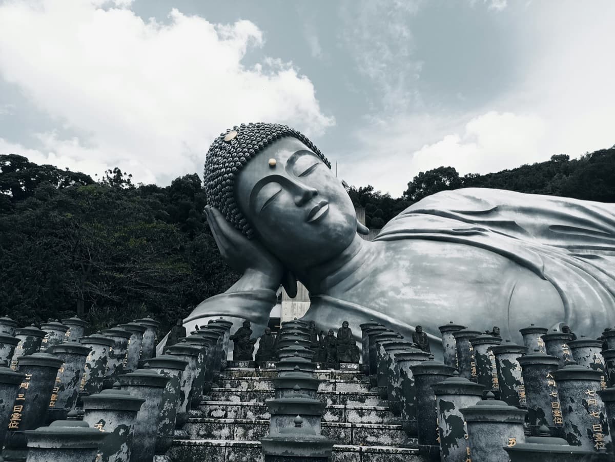 The huge bronze reclining Buddha at Nanzoin temple with rows of small stone statues in front of it
