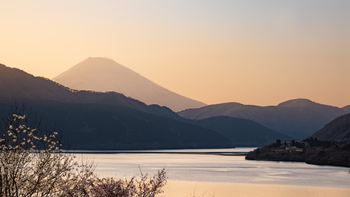 Mount Fuji glowing at dawn above the hills around Lake Ashi in Hakone