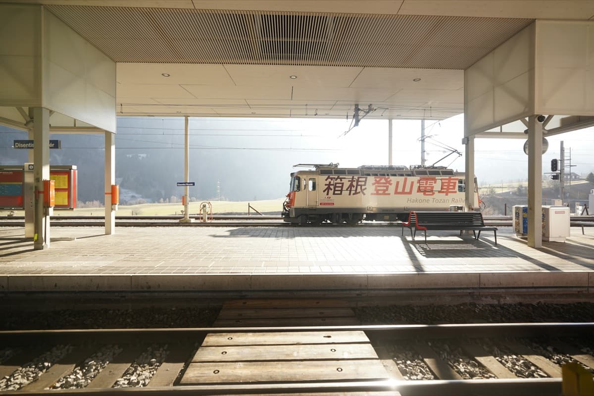 A red and white Hakone Tozan Railway car standing at a mountain station platform