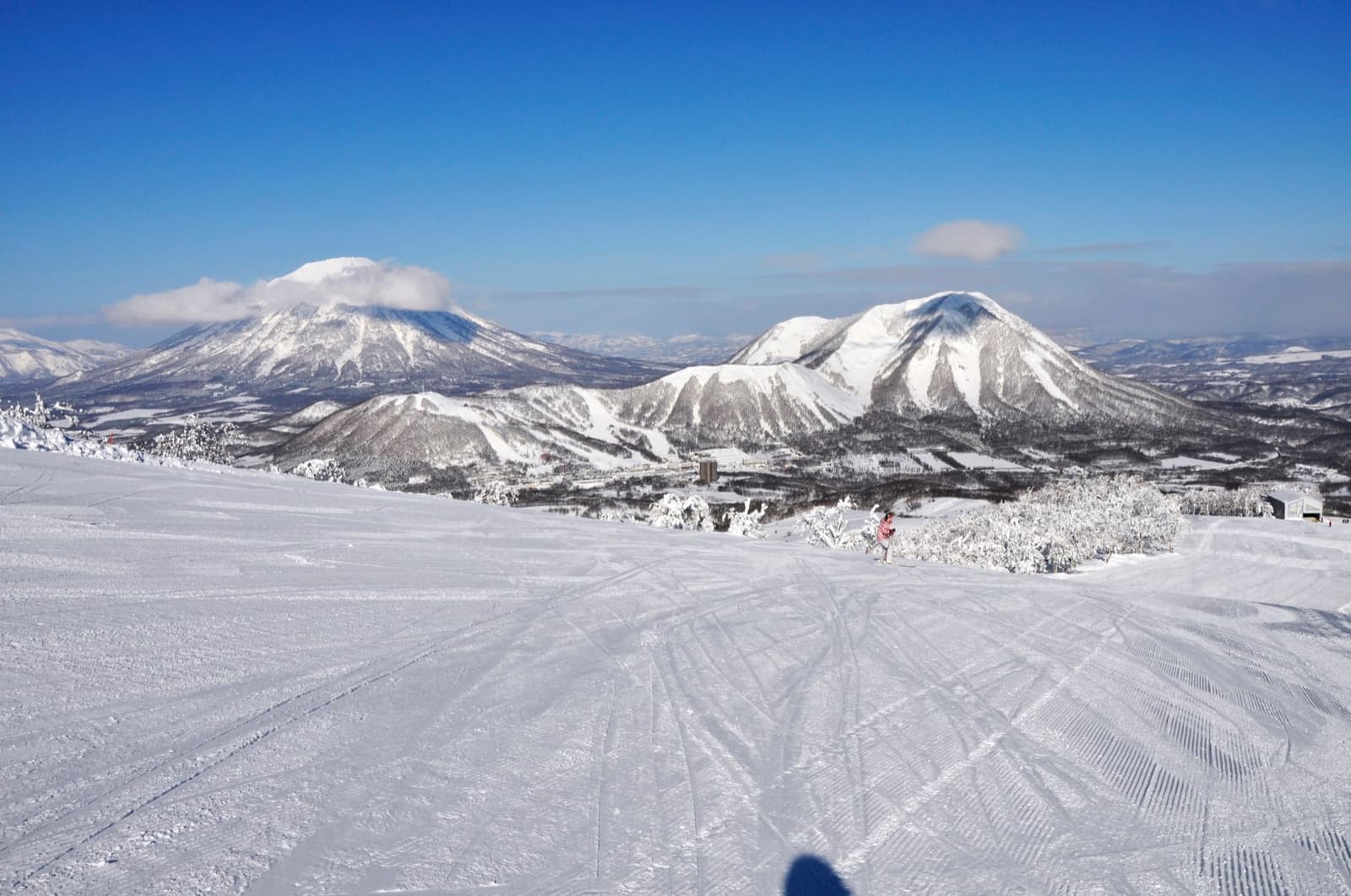 A groomed Rusutsu run looking out to the snow-capped cone of Mount Yotei and the neighbouring peaks
