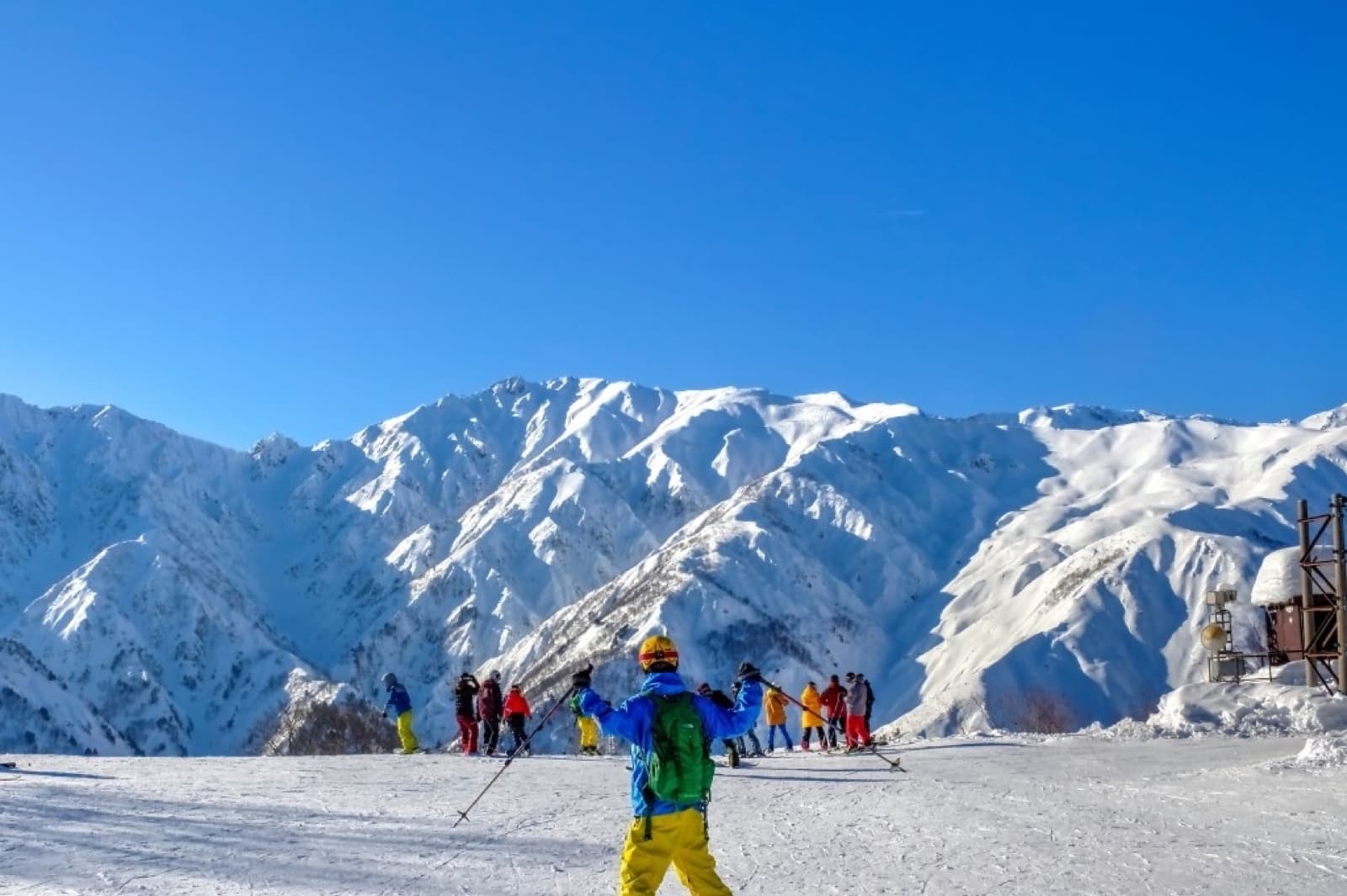 Skieur sur un plateau enneigé dominant la chaîne de Hakuba