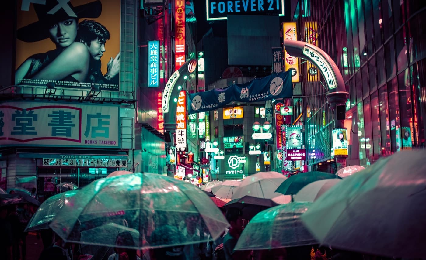 People crossing a rainy Shibuya street in Tokyo