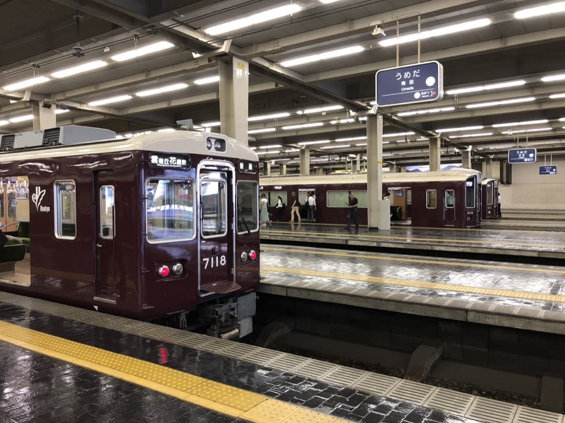 Maroon Hankyu trains waiting at the platforms of Osaka-Umeda Station