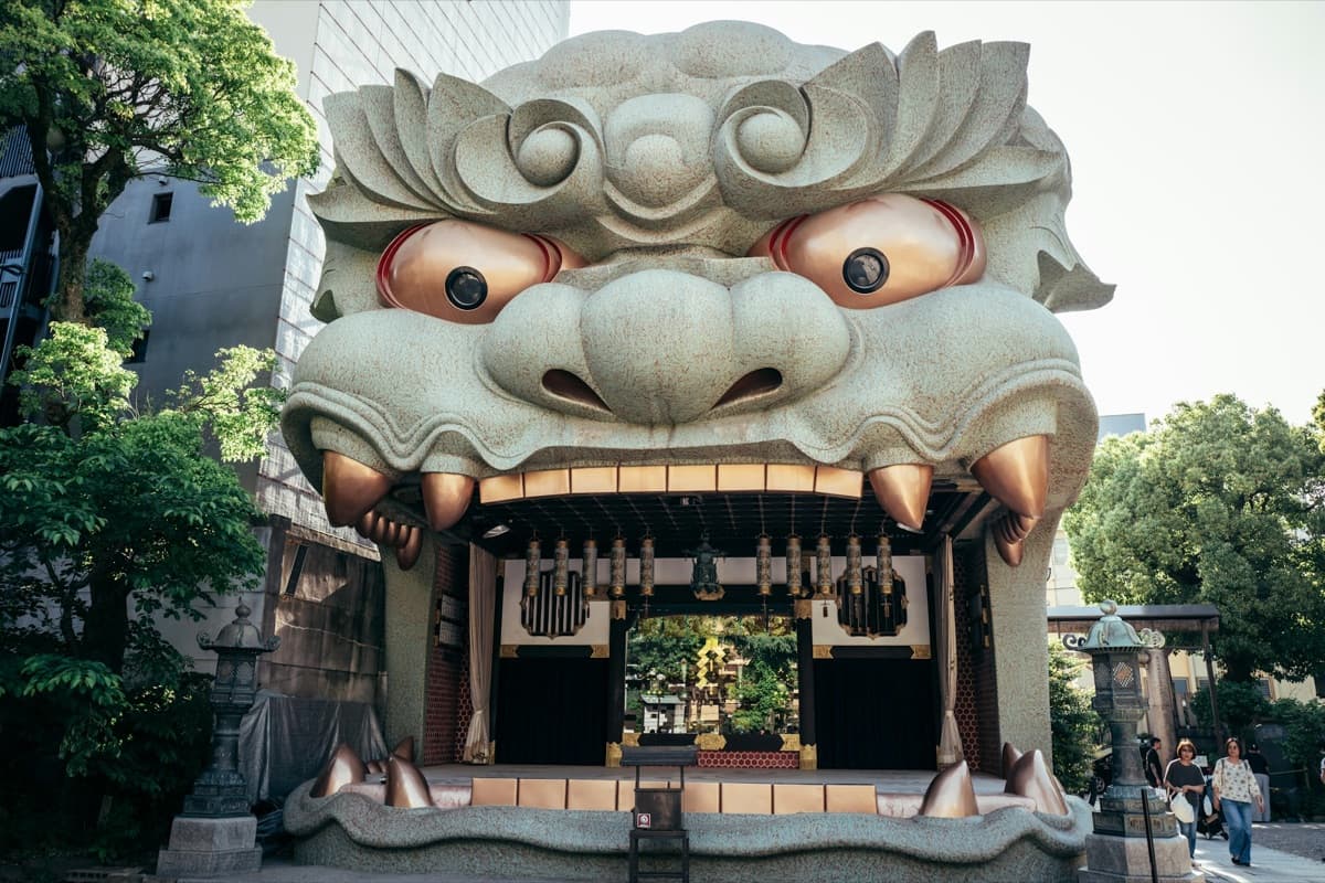El enorme escenario con forma de cabeza de león del santuario Namba Yasaka, con la boca abierta, farolas de piedra y árboles