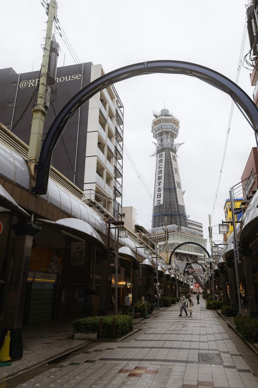 La torre Tsutenkaku al final de una tranquila calle comercial cubierta de Shinsekai