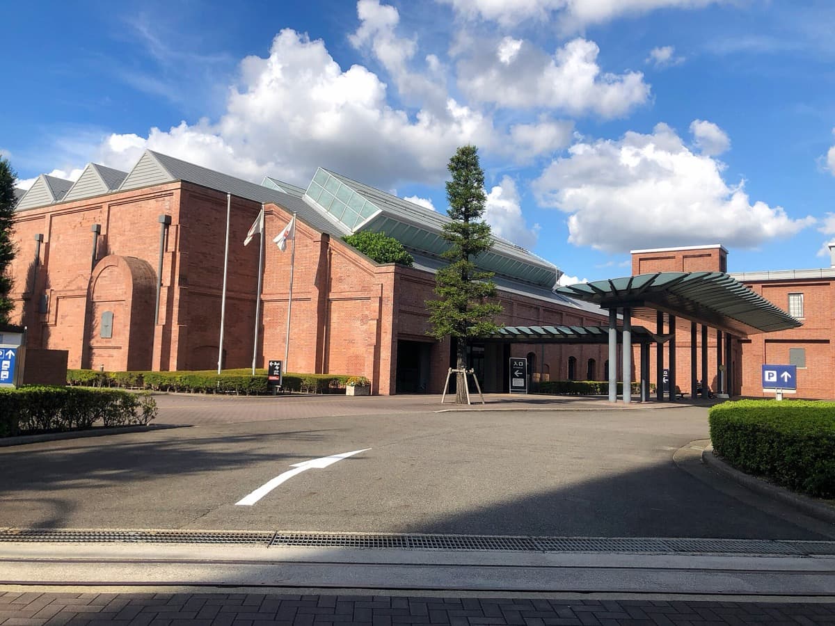 The main gate of the Toyota Commemorative Museum of Industry and Technology with red-brick buildings under a blue sky