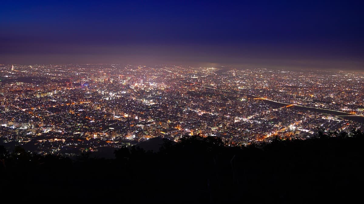 The lights of Sapporo spread across the plain at night seen from the summit of Mt. Moiwa