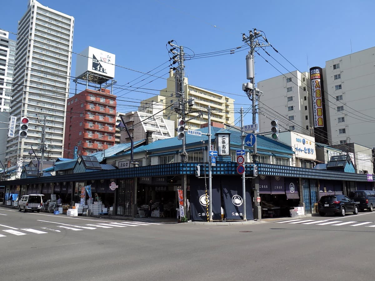 The street-front stalls of Nijo Market in central Sapporo under a blue sky