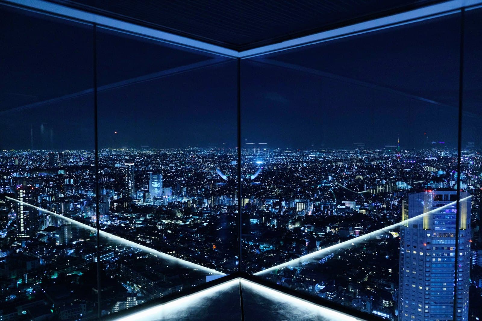 Las luces de Tokio y la torre de Tokio desde la terraza acristalada de Shibuya Sky