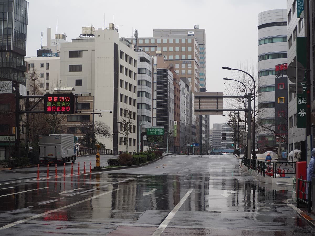 A wide Tokyo avenue, Eitai-dori in Kayabacho, empty of traffic on a wet morning with office buildings on both sides