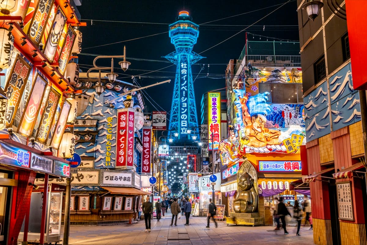 La torre Tsutenkaku sobre las calles iluminadas de Shinsekai de noche