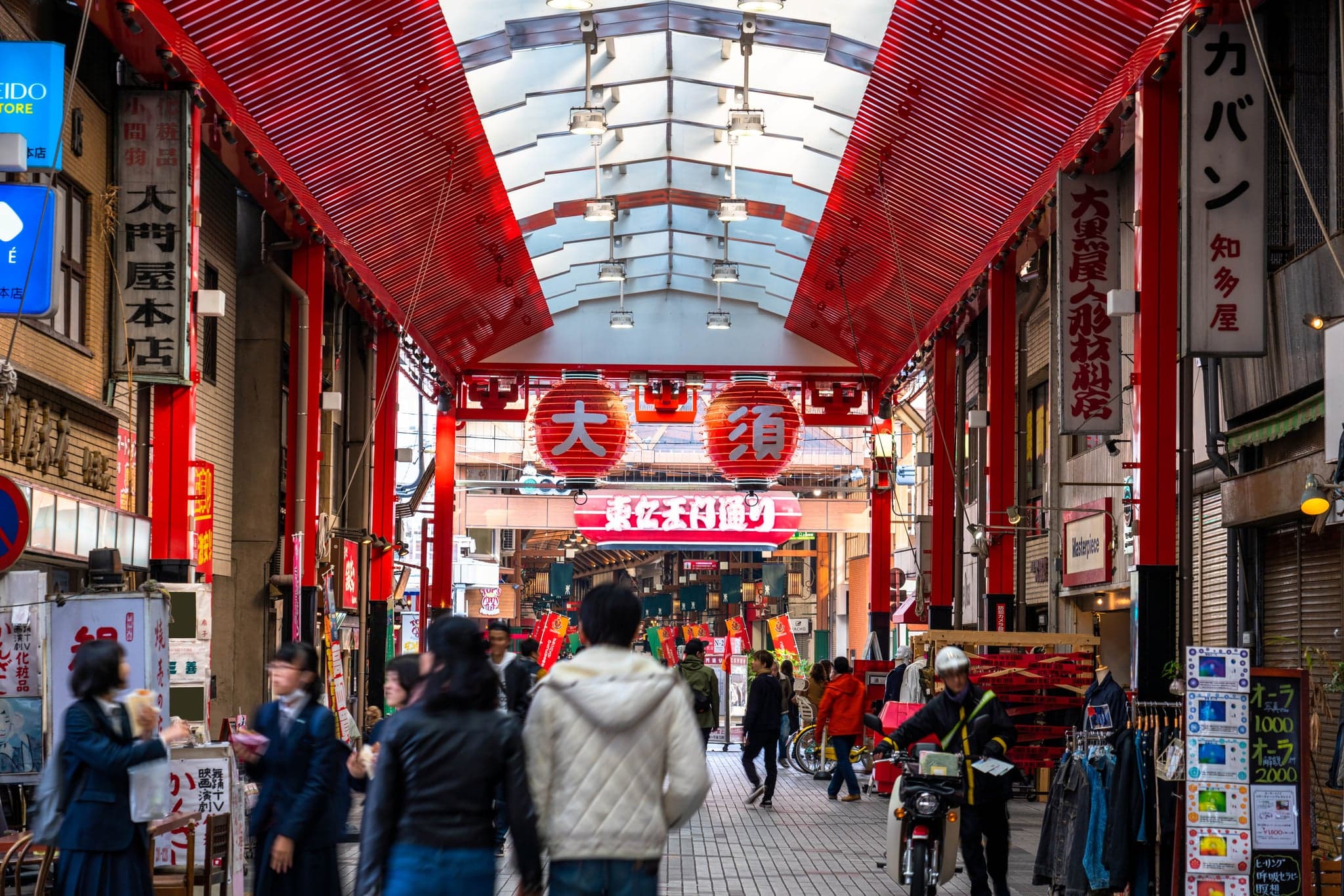 The covered Osu shopping arcade with red lanterns overhead and shoppers walking below