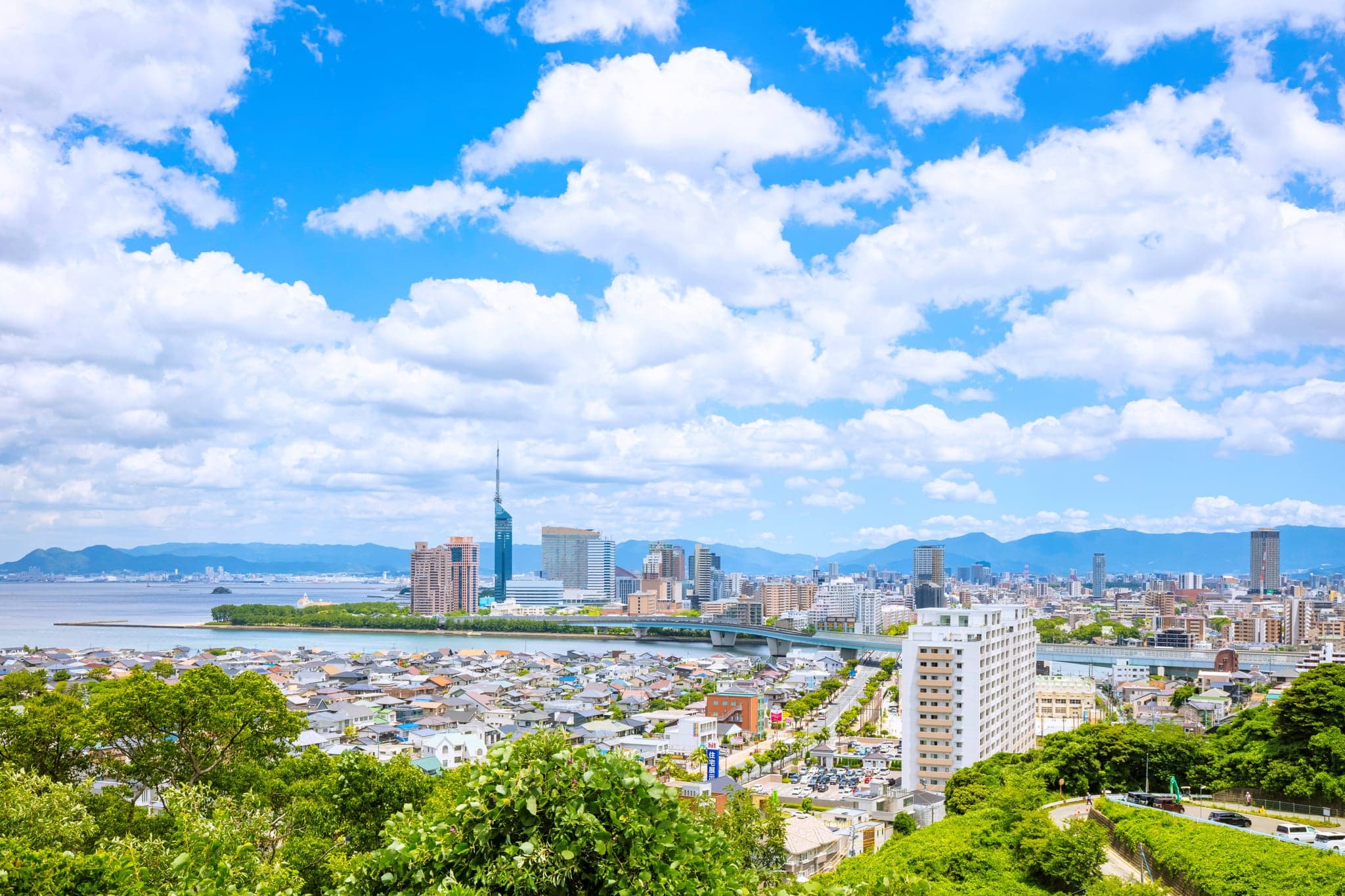 Fukuoka city spread along Hakata Bay with Fukuoka Tower on the waterfront and hills behind