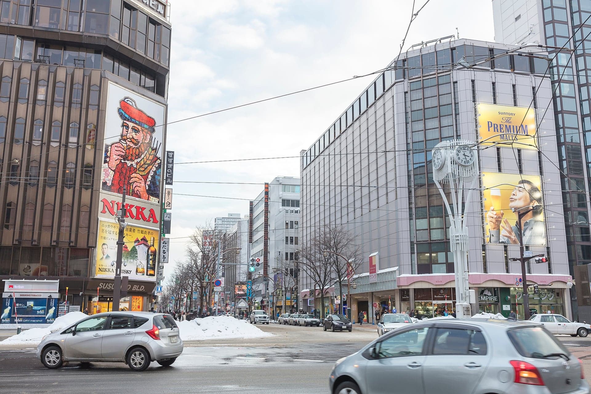 The Susukino crossing in winter with the Nikka whisky sign on a building corner and snow on the street