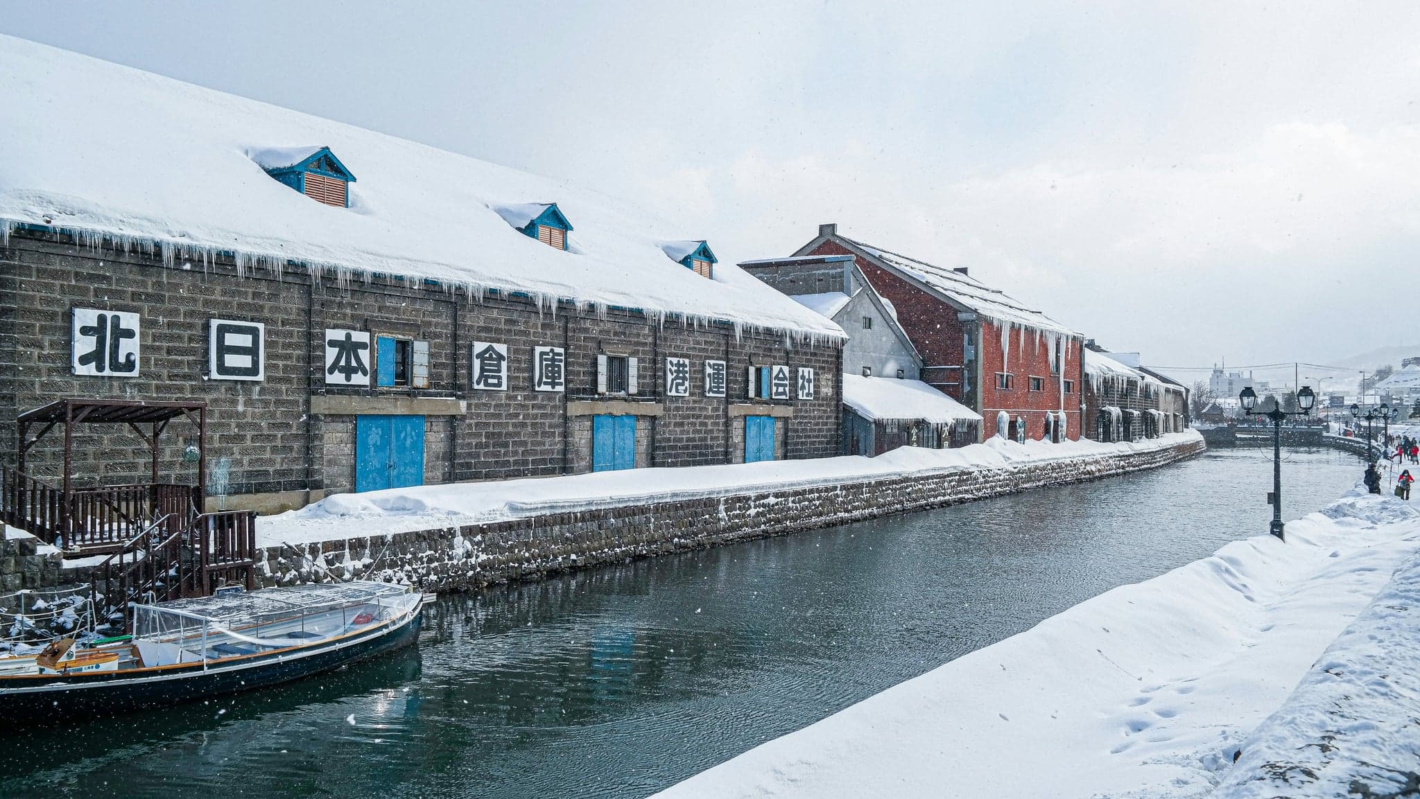 The Otaru Canal with snow on its banks and old stone warehouses along the water